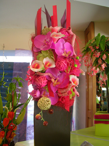 Haute composition d'orchidées roses et fuchsia dans un vase noir