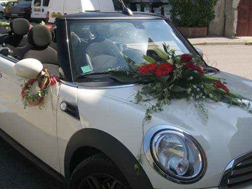 Voiture de mariés décorée d'une composition de roses rouges